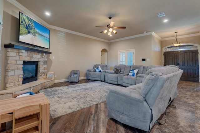 living room featuring ornamental molding, dark hardwood / wood-style flooring, ceiling fan, and a fireplace