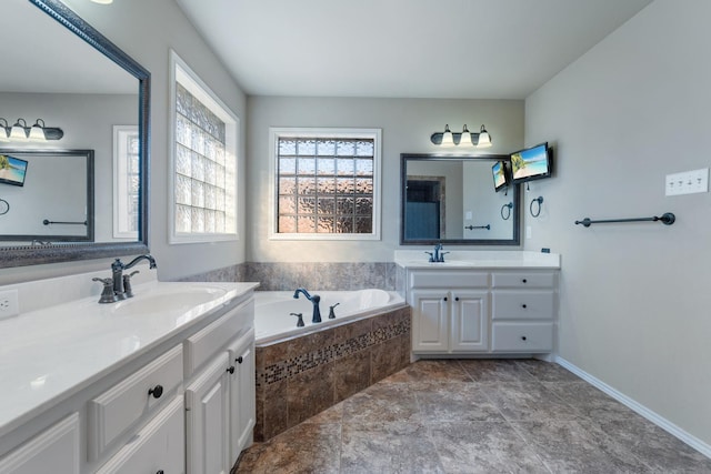 bathroom featuring vanity and tiled tub