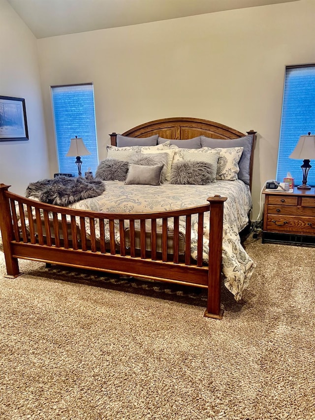 carpeted bedroom with lofted ceiling