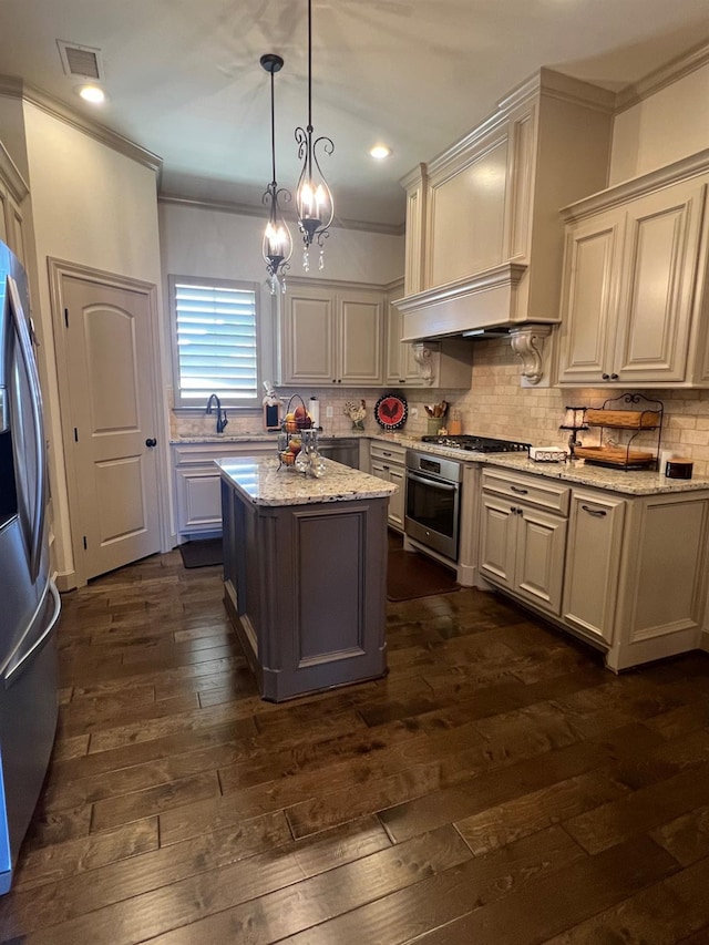 kitchen with decorative light fixtures, decorative backsplash, a center island, stainless steel appliances, and light stone countertops