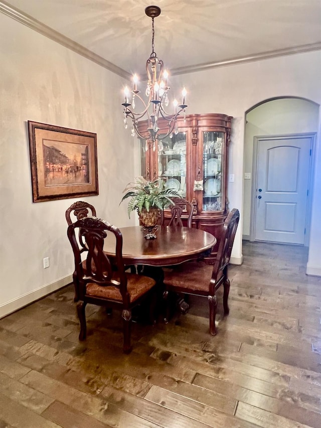 dining room featuring crown molding, hardwood / wood-style floors, and a notable chandelier