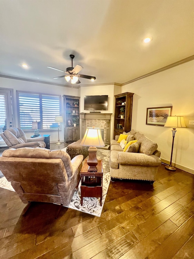 living room with wood-type flooring, ornamental molding, and ceiling fan