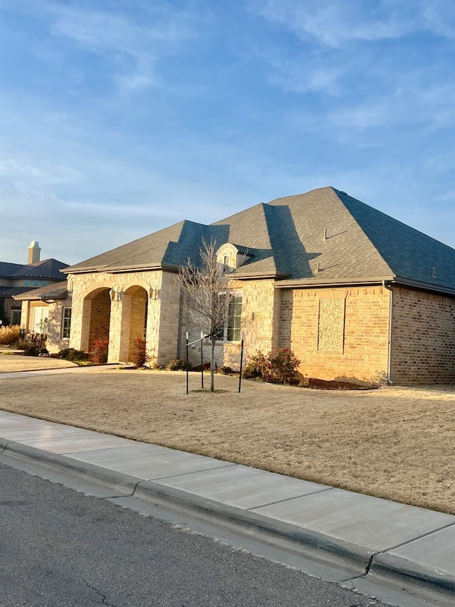 french country inspired facade featuring a front lawn