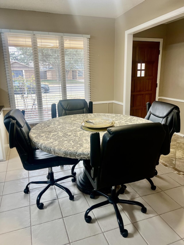 dining area with plenty of natural light, tile patterned flooring, and baseboards