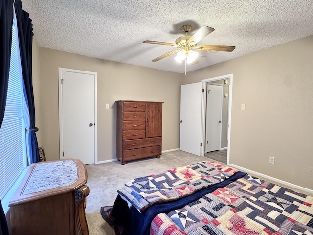 bedroom featuring ceiling fan, baseboards, a textured ceiling, and light colored carpet