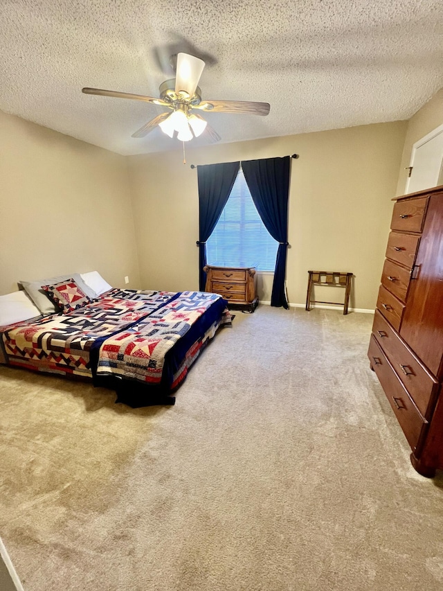 carpeted bedroom featuring a textured ceiling, baseboards, and a ceiling fan