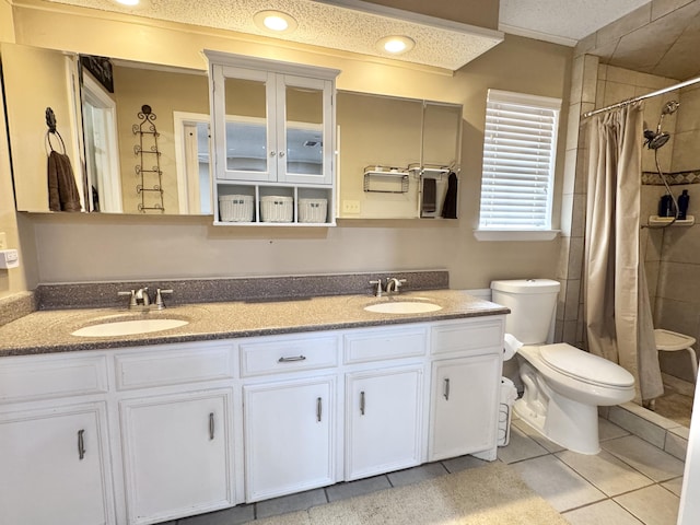 bathroom featuring tile patterned flooring, a sink, toilet, and double vanity