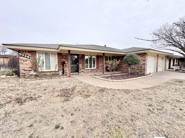 ranch-style house featuring brick siding, driveway, and an attached garage