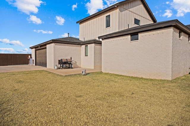 back of house with a yard, board and batten siding, and fence