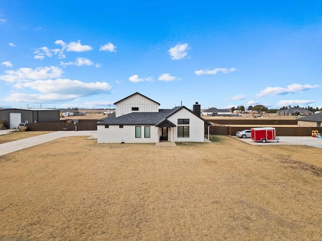 modern farmhouse style home featuring fence and a chimney