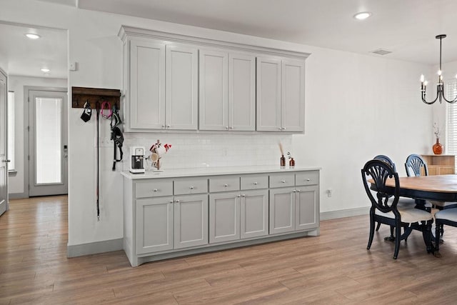 dining room featuring a notable chandelier, light wood-style floors, visible vents, and baseboards