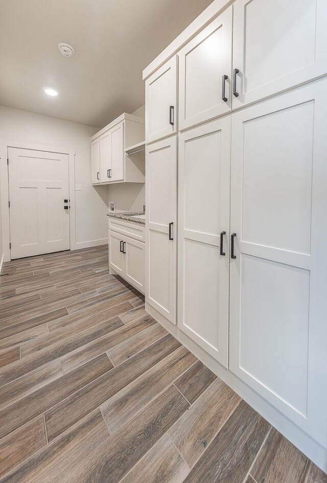 mudroom featuring recessed lighting, light wood-style flooring, and baseboards