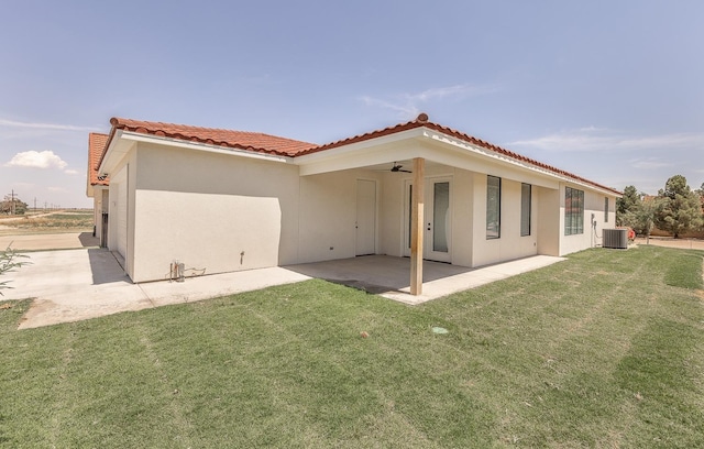 back of house with a tiled roof, a lawn, a patio, and a ceiling fan