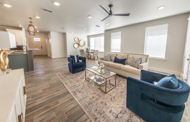 living room featuring visible vents, recessed lighting, wood finished floors, arched walkways, and a ceiling fan