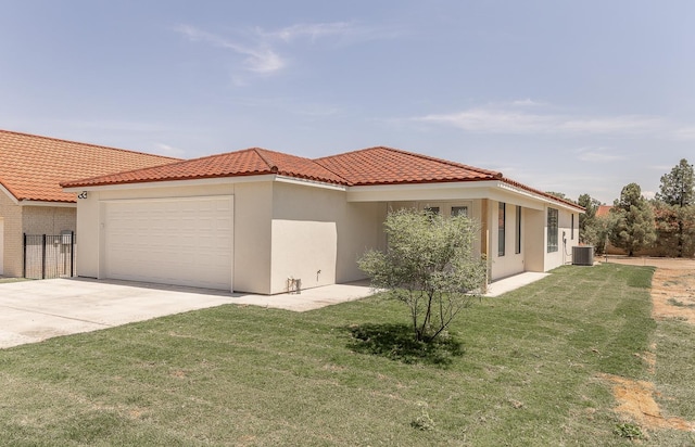 mediterranean / spanish house featuring central AC, a front lawn, concrete driveway, a garage, and a tiled roof