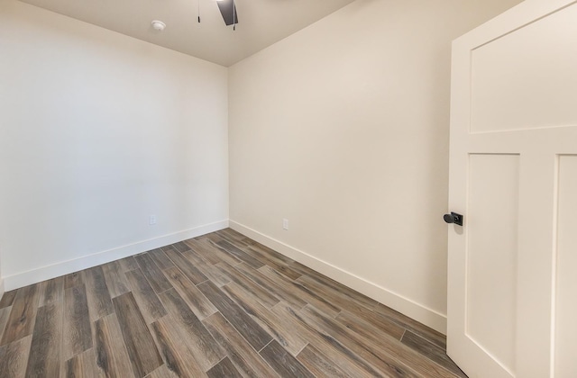 spare room featuring ceiling fan, baseboards, and dark wood finished floors