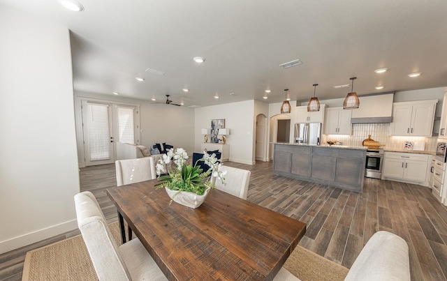 dining space with visible vents, baseboards, recessed lighting, arched walkways, and dark wood-style flooring