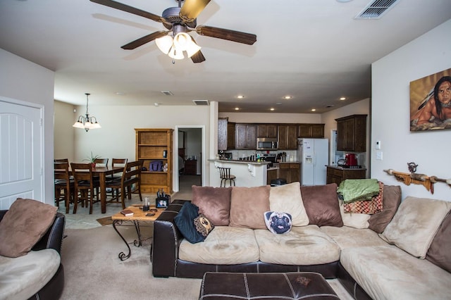 living room featuring light colored carpet and ceiling fan with notable chandelier