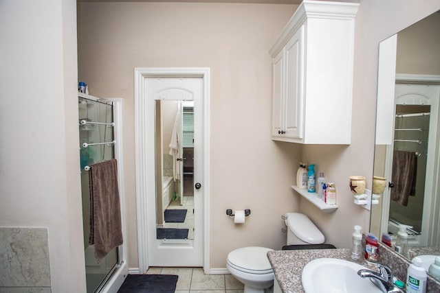 bathroom featuring vanity, tile patterned floors, toilet, and walk in shower