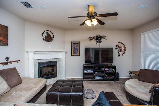 living room featuring ceiling fan, a fireplace, and light carpet