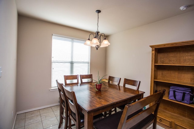 tiled dining space featuring an inviting chandelier