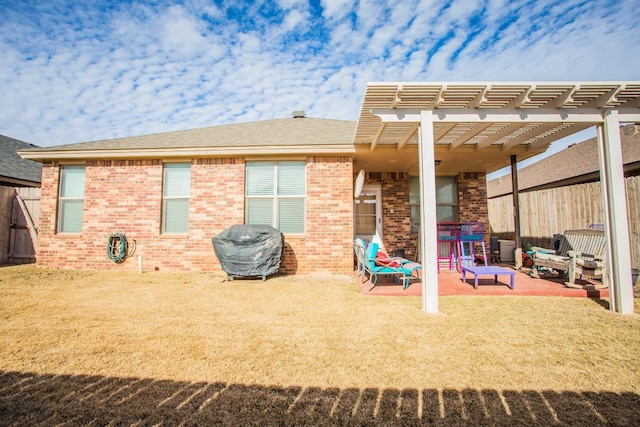 back of house with a pergola, a patio, and a lawn