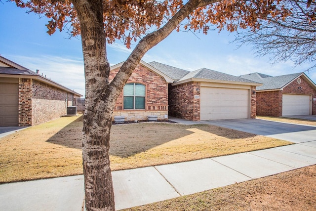 ranch-style house with a garage, a front yard, and central air condition unit