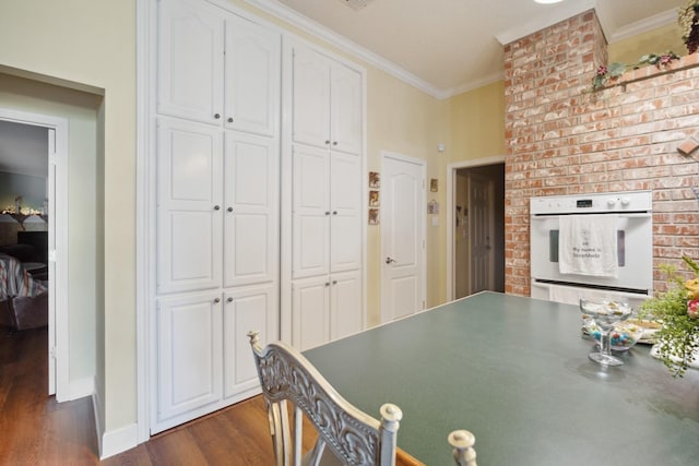 interior space with dark wood-type flooring and ornamental molding