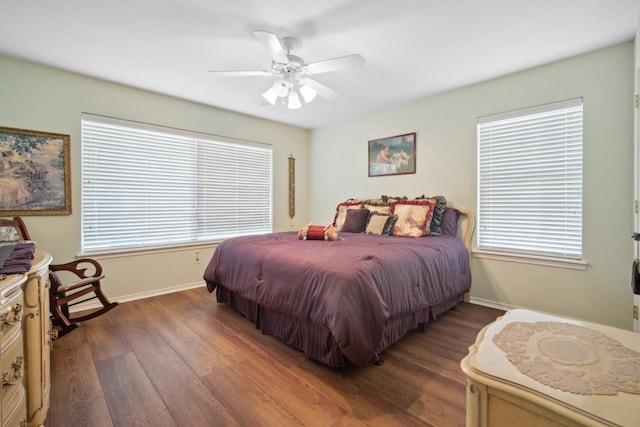 bedroom with ceiling fan, dark hardwood / wood-style flooring, and multiple windows