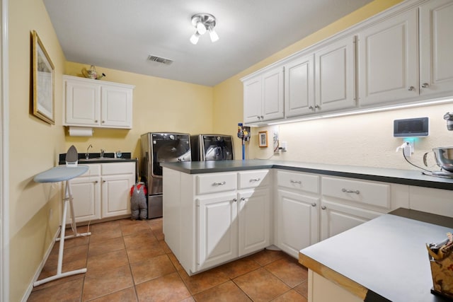 kitchen featuring separate washer and dryer, light tile patterned floors, kitchen peninsula, and white cabinets