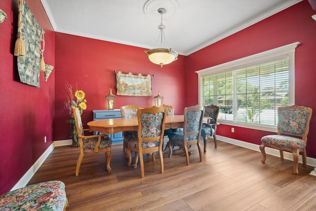 dining space with crown molding and hardwood / wood-style floors