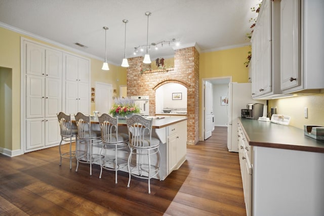 kitchen with white cabinetry, a kitchen breakfast bar, hanging light fixtures, and a kitchen island