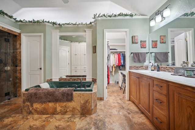 bathroom featuring vanity, vaulted ceiling, and shower with separate bathtub