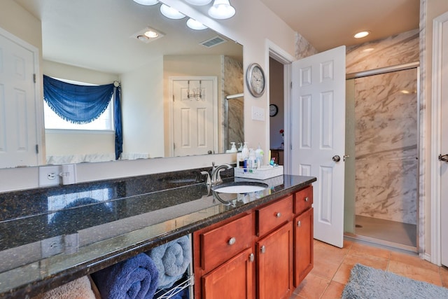 bathroom featuring vanity, tile patterned flooring, and a shower with door