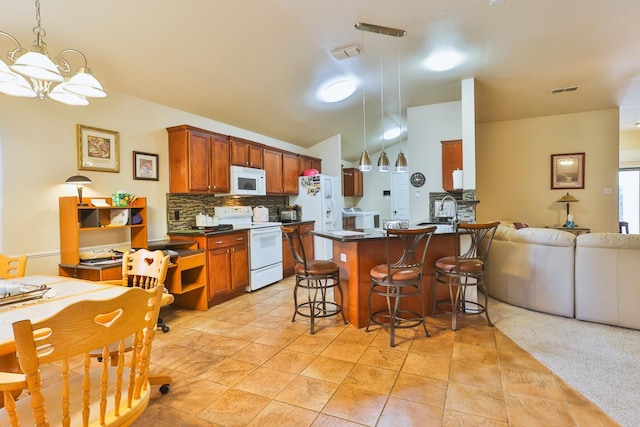 kitchen featuring a breakfast bar area, decorative backsplash, hanging light fixtures, kitchen peninsula, and white appliances