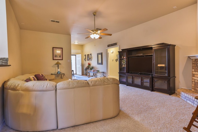 carpeted living room with ceiling fan and a fireplace