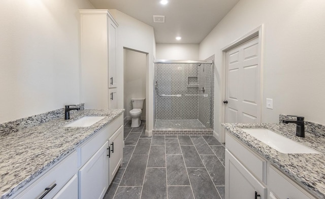 bathroom featuring vanity, an enclosed shower, and toilet