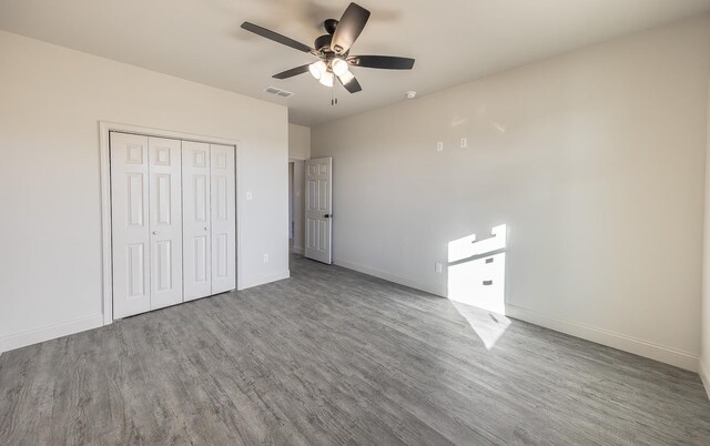 unfurnished bedroom with hardwood / wood-style flooring, a closet, and ceiling fan