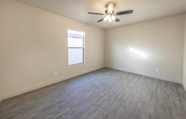 empty room with dark hardwood / wood-style floors and ceiling fan