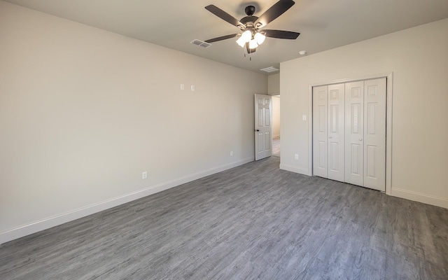 unfurnished bedroom featuring a closet, dark hardwood / wood-style floors, and ceiling fan