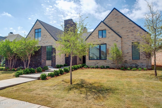 4029 136th St, Lubbock, TX 79423 - tudor-style house with brick siding, a chimney, and a front lawn