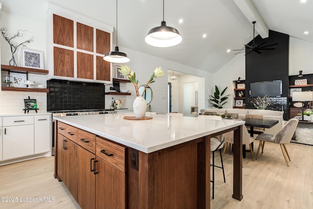 4029 136th St, Lubbock, TX 79423 - kitchen featuring open shelves, light wood finished floors, tasteful backsplash, a kitchen island, and white cabinetry
