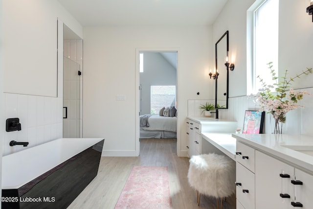 4029 136th St, Lubbock, TX 79423 - full bath with vanity, wood finished floors, a freestanding bath, ensuite bath, and a shower with shower door