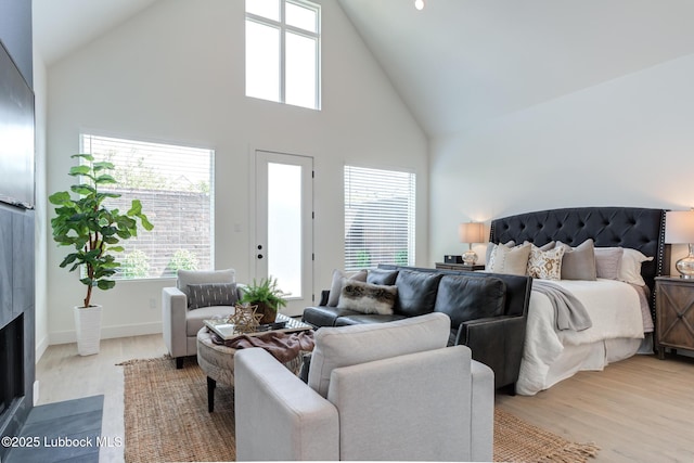 4029 136th St, Lubbock, TX 79423 - bedroom with high vaulted ceiling, light wood-type flooring, a fireplace with flush hearth, and baseboards