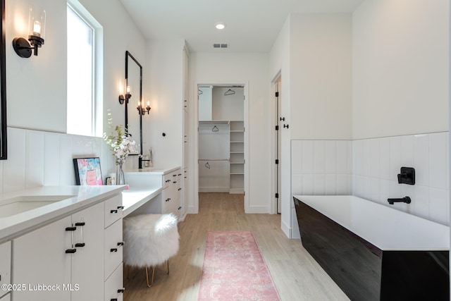 4029 136th St, Lubbock, TX 79423 - full bathroom with vanity, wood finished floors, a bath, a spacious closet, and recessed lighting