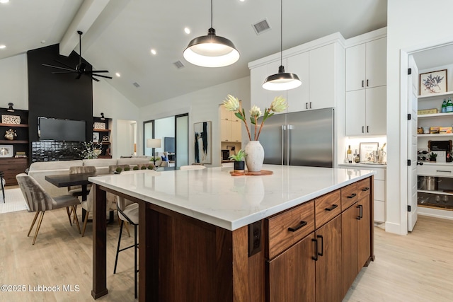 4029 136th St, Lubbock, TX 79423 - kitchen with stainless steel built in refrigerator, light wood-style floors, beamed ceiling, a center island, and white cabinets