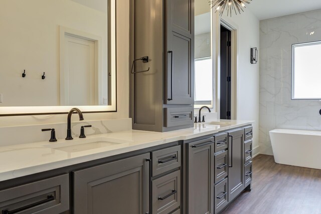7710 46th St, Lubbock, TX 79407 - full bath with double vanity, a freestanding bath, and wood finished floors