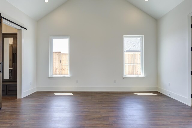 7710 46th St, Lubbock, TX 79407 - unfurnished room featuring a barn door, dark wood finished floors, high vaulted ceiling, and recessed lighting
