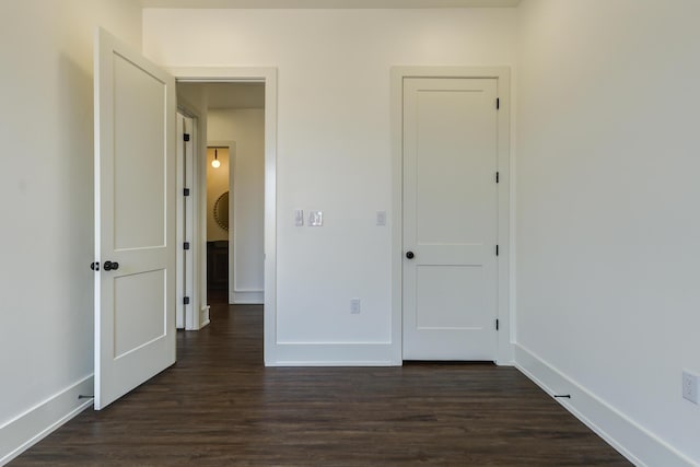7710 46th St, Lubbock, TX 79407 - unfurnished bedroom with baseboards and dark wood-type flooring