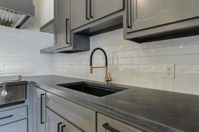 7710 46th St, Lubbock, TX 79407 - kitchen featuring extractor fan, tasteful backsplash, and dark stone counters